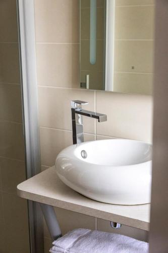 a bathroom with a sink and a mirror at Hôtel du Mail in Angers