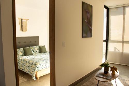 a bedroom with a bed and a table and a mirror at Norte Cali - Bosque Living- 301 in Cali