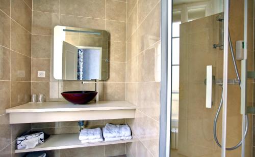 a bathroom with a sink and a mirror and a shower at Hôtel du Mail in Angers