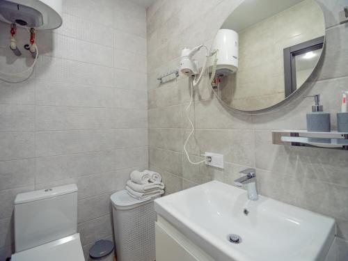 a bathroom with a sink and a mirror and a toilet at Smart House Apartments in Lviv