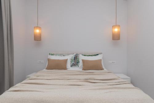 a bedroom with a large bed with two lights at Camelia Luxury Suites in Psarou