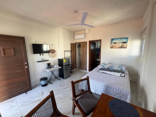 a bedroom with a bed and a table and chairs at Estudio cerca del mar 2 in Puerto Morelos