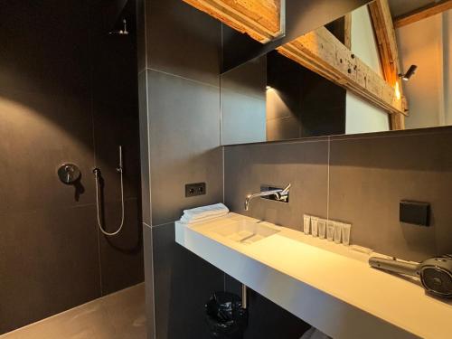 a bathroom with a sink and a shower at Kazerne Hotel - Member of Design Hotels in Eindhoven