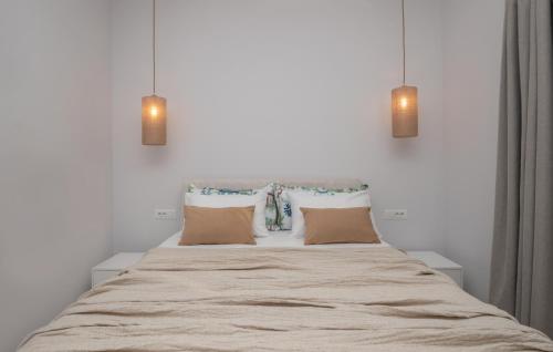 a bedroom with a bed with pillows and two lights at Camelia Luxury Suites in Psarou