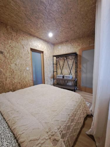 a bedroom with a large bed in a room at CASA DO BENTO - Rustic Cozy Loft, Vila do Conde in Fajozes