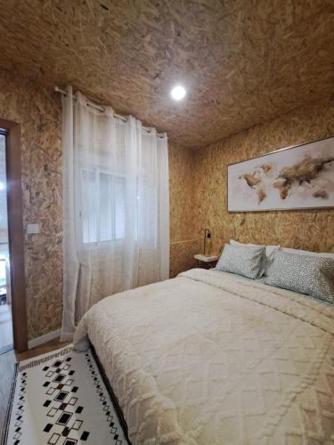 a bedroom with a large bed and a stone wall at CASA DO BENTO - Rustic Cozy Loft, Vila do Conde in Fajozes