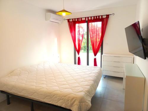 une chambre avec un lit et une fenêtre avec des rideaux rouges dans l'établissement Spirit Of South, à Carsan