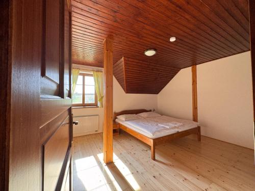 a bedroom with a bed and a wooden ceiling at Penzion Terezka in Králíky