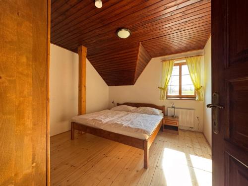 a bedroom with a bed and a wooden ceiling at Penzion Terezka in Králíky