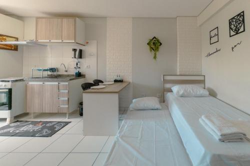 a kitchen and a bedroom with two beds in a room at CID305C Functional Apartment in Maringá