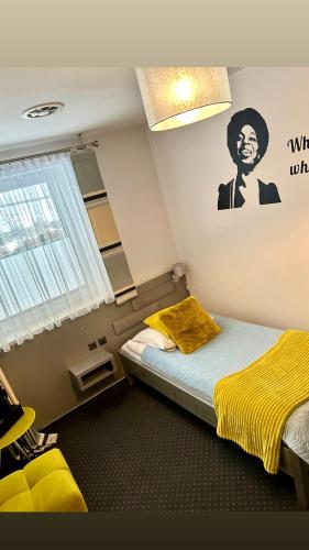 a bedroom with a bed with a yellow blanket on it at Piano in Nowy Sącz