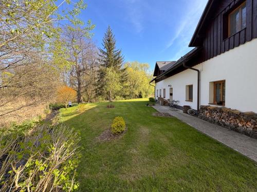 a house with a grass yard next to a building at Penzion Terezka in Králíky