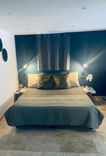 une chambre avec un grand lit avec un mur bleu dans l'établissement Chalet détente proche plage, à La Ciotat