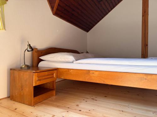 a bedroom with a bed and a table with a lamp at Penzion Terezka in Králíky