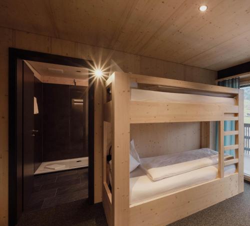 a bunk bed in a room with a shower at Frutigresort in Frutigen