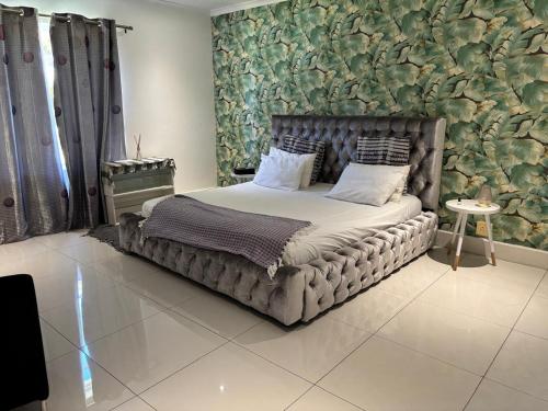 een slaapkamer met een groot bed en een stenen muur bij yalwa house in Sweet Valley