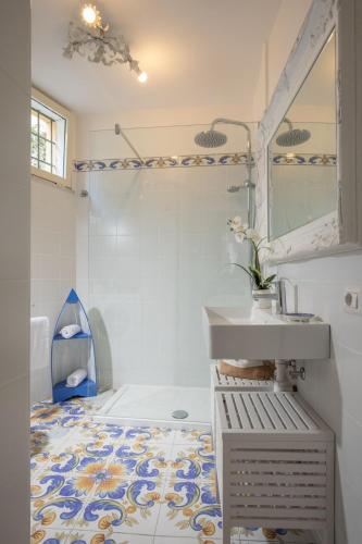a bathroom with a sink and a mirror at Daplace - Scalinata Apartment in Positano