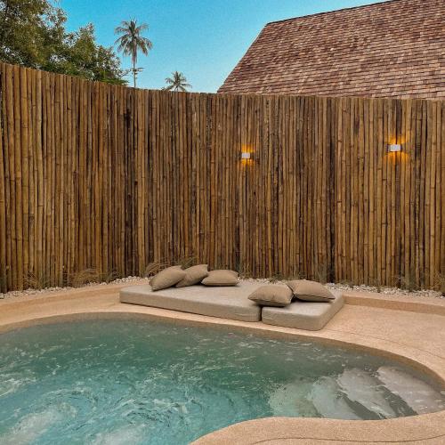a pool with two pillows and a wooden fence at Rest Sea Resort Koh Kood in Ko Kood