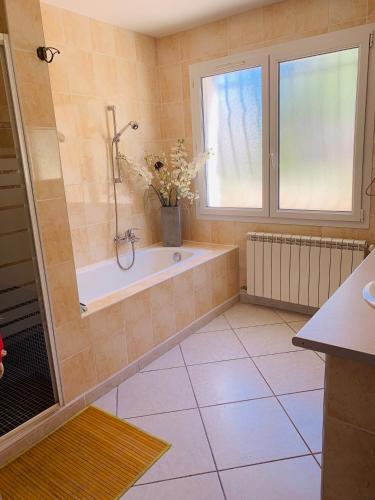 une salle de bain avec une baignoire et une fenêtre dans l'établissement Rez de villa SAINT RAPHAËL, à Saint-Raphaël