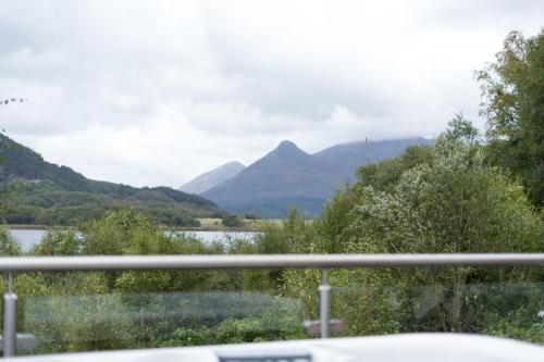 a view of a lake and mountains from a car at The Heronry Hideaway with luxury hot tub in Ballachulish