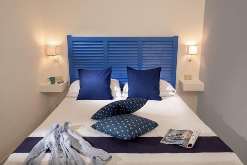 a bedroom with a blue headboard and pillows on a bed at Daplace - Scalinata Apartment in Positano