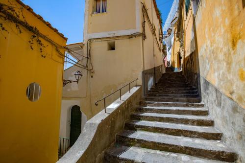 a set of stairs in an alley between buildings at Daplace - Scalinata Apartment in Positano