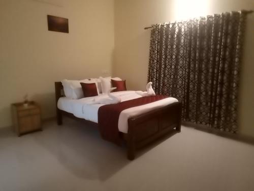 a small bedroom with two beds and a window at Airport villa in Chewarra