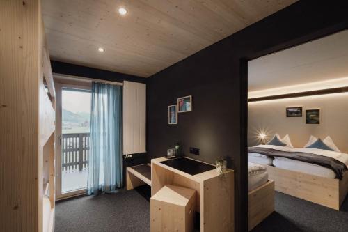 a bedroom with a bed and a large window at Frutigresort in Frutigen