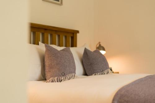 a bedroom with a bed with pillows on it at The Heronry Hideaway with luxury hot tub in Ballachulish