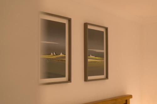 two mirrors on the wall of a room at The Heronry Hideaway with luxury hot tub in Ballachulish