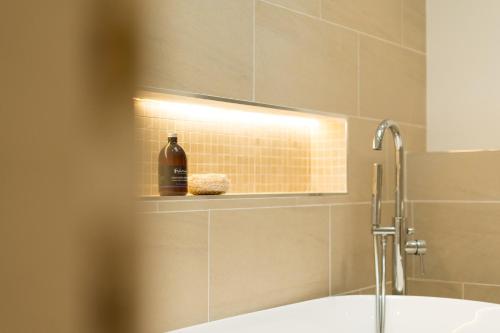 a bathroom with a sink and a bottle on a shelf at The Heronry Hideaway with luxury hot tub in Ballachulish