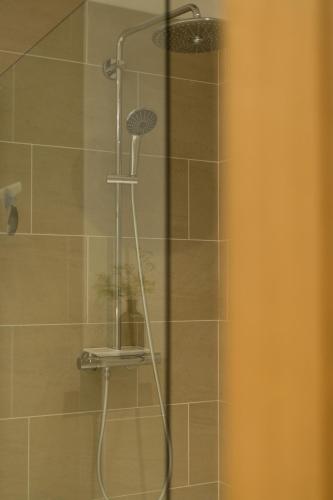 a shower with a shower head in a bathroom at The Heronry Hideaway with luxury hot tub in Ballachulish