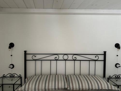 a bed with a black metal headboard in a bedroom at La terrazza di Lillo in Carovigno