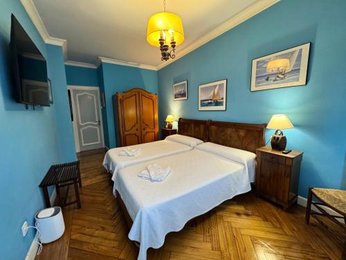 a bedroom with a white bed and blue walls at Palacio Pampinot in Hondarribia