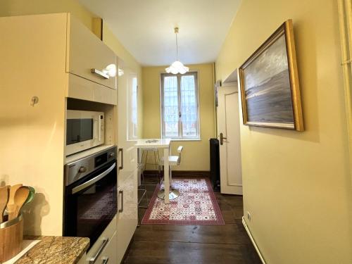 une petite cuisine avec une table et une fenêtre dans l'établissement l'ARMAGNAC, à Rodez