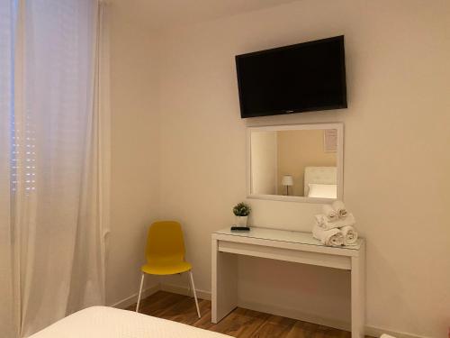 ein Schlafzimmer mit einem Schreibtisch mit einem Spiegel und einem gelben Stuhl in der Unterkunft Il Rifugio in Sulmona