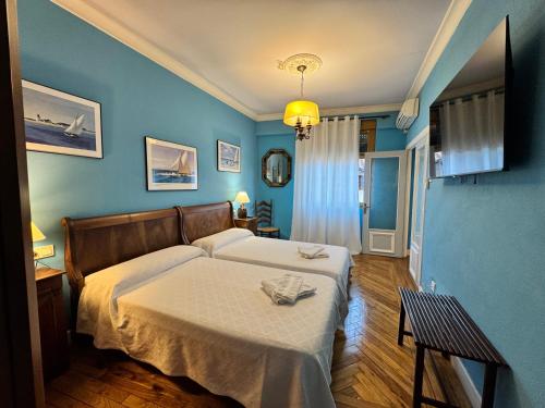 a bedroom with a bed and a blue wall at Palacio Pampinot in Hondarribia