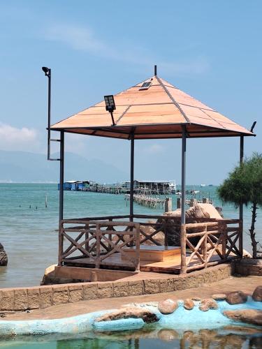 a large wooden pavilion next to a body of water at Green Oasis Nha Trang Resort in Nha Trang