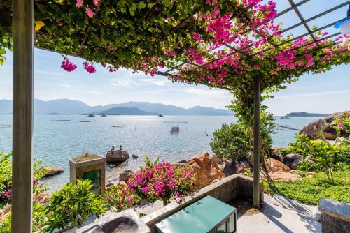 a view of the water and flowers at Green Oasis Nha Trang Resort in Nha Trang