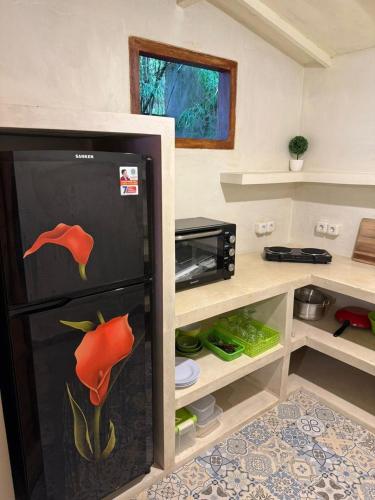 a kitchen with a refrigerator with a flower painted on it at Villa Anjing in Nusa Dua