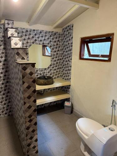 a bathroom with a white toilet and a sink at Villa Anjing in Nusa Dua