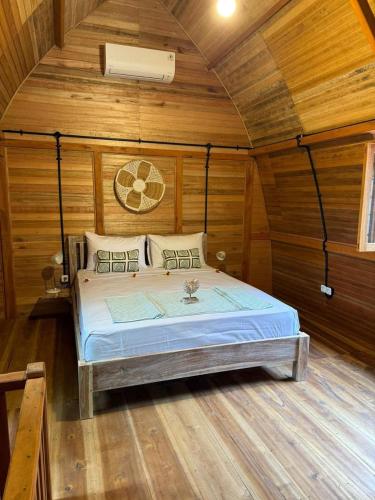 a bedroom with a bed in a wooden room at Villa Anjing in Nusa Dua