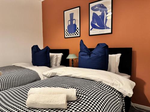 two beds with blue and white pillows in a room at BIG House for Business Stays in Barnsley with 6-bedrooms & 8 Beds by PureStay in Barnsley