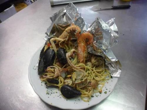 a plate of pasta with shrimp and mussels in foil at Locanda Primo Sole in Oneto