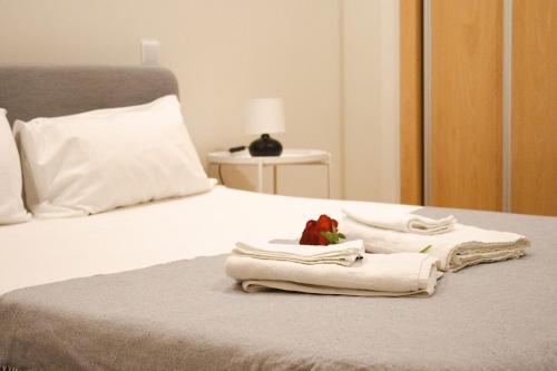 a bed with towels and a stuffed animal on it at PBH Hostel in Porto