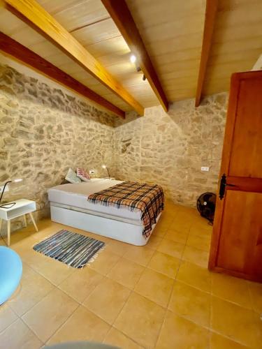 a bedroom with a bed in a stone wall at Villas2meet Jimmy Lloret in Lloret de Vistalegre