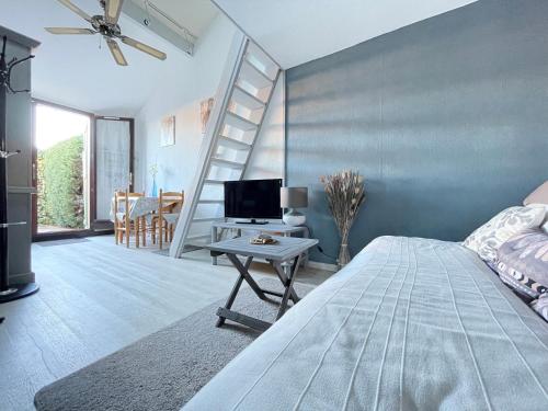 - une chambre avec un lit et une table avec une télévision dans l'établissement Maison avec piscine clim parking, à Leucate