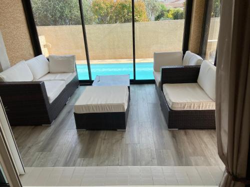 - un salon avec deux canapés et une piscine dans l'établissement Villa Saint Laurent D'Aigouze, à Saint-Laurent-dʼAigouze