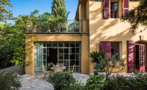a patio with a table and chairs in front of a building at Le Pigonnet - Esprit de France in Aix-en-Provence