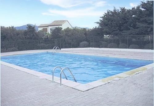 une grande piscine avec de l'eau bleue dans une cour dans l'établissement Appartement 2 pièces - 6 personnes SAINT CYPRIEN PLAGE SC090-232, à Saint Cyprien Plage
